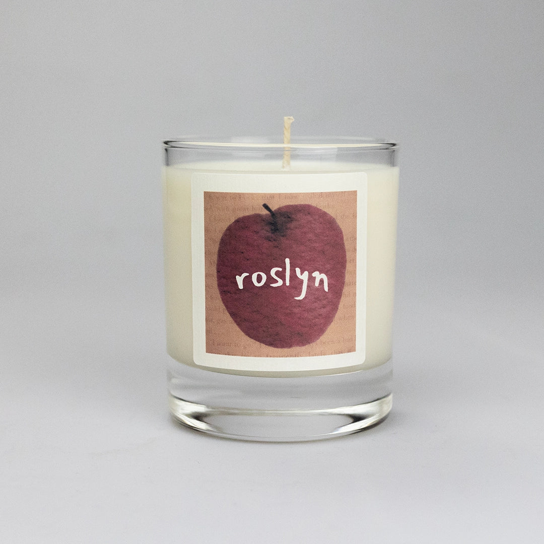 Product photo of scented soy candle Roslyn, made by BONKI. Candle in glass jar. Brown label with red apple and writing "Roslyn".