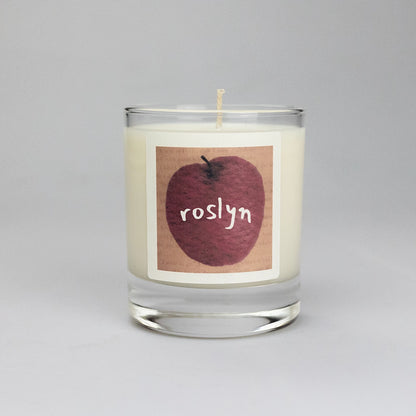 Product photo of scented soy candle Roslyn, made by BONKI. Candle in glass jar. Brown label with red apple and writing "Roslyn".