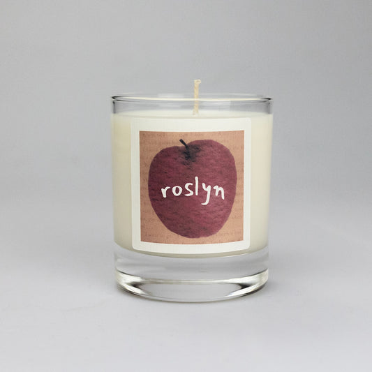 Product photo of scented soy candle Roslyn, made by BONKI. Candle in glass jar. Brown label with red apple and writing "Roslyn".